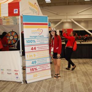 Person posing by sign with hunger facts