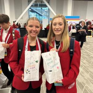 Two people posing with bags of food