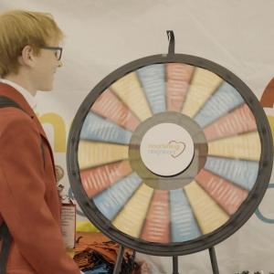 Person standing in front of spinner wheel