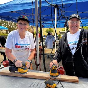 People sanding wood planks