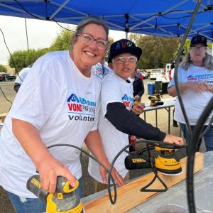 People sanding wood planks