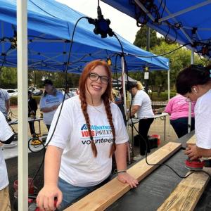 People sanding wood planks