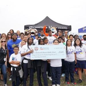 Group of people holding a check in front of Albertsons' tent
