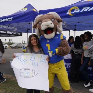 Los Angeles Rams' mascot poses with person holding a "Thank you" sign