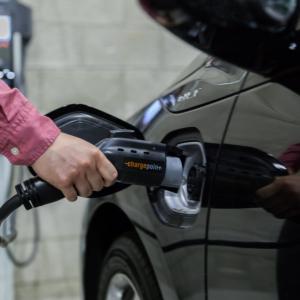 A person charging an electric vehicle