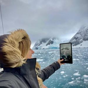 Gádor in a parka, viewing icy water through a tablet screen