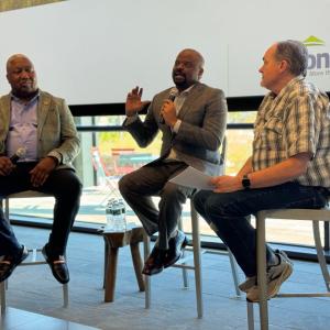 Three people sat on chairs having a discussion 