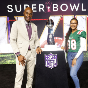 Two people stood near the super bowl trophy 