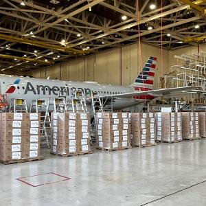 Boxes stacked in front of an American Airlines plane