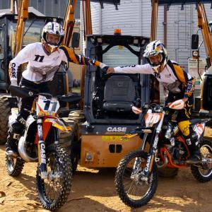 Two people on motorbikes fist bumping 