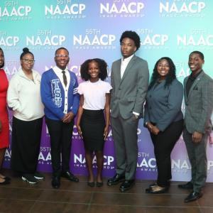 A group of people stood in front of a NAACP Image Awards event backdrop 