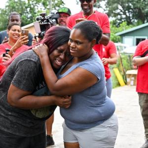 Two women hugging, surrounded by Wells Fargo Volunteers