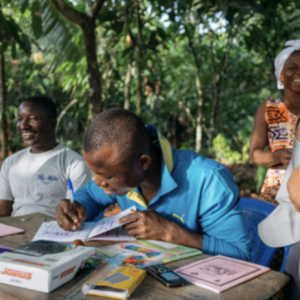 A person sat at a desk writing in a book 