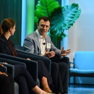 People seated in chairs on a stage and discussing