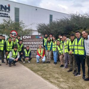 People in safety vests standing next to a sign for CNH