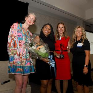 Four people smiling and standing together