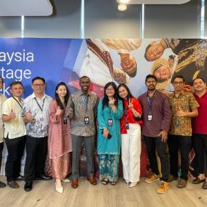 A group posing in front of a sign