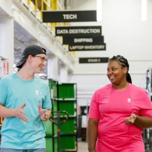 Two smiling people talking and walking inside a building