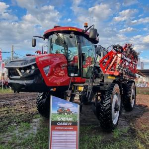 Tractors and equipment in a field under a cloudy sky