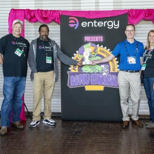 People standing together next to an Entergy sign