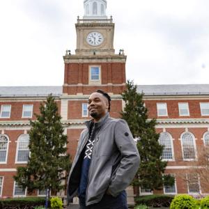 Dr. Kofi LeNiles stands in front of a building