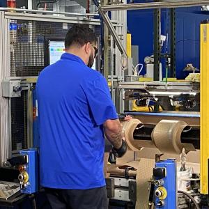 A person standing at a machine