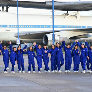 She Is an Astronaut participants in a line in front of a Nasa airplane