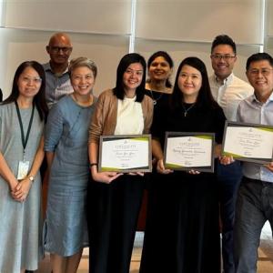 A group of people standing together, holding diplomas