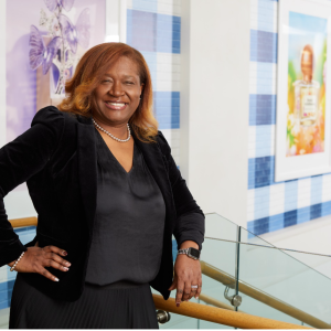 Kelie Charles smiles at the camera while standing at the top of a set of steps at the Bath & Body Works headquarters building in Columbus, Ohio.
