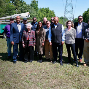 People standing together in a field in front of communication equipment