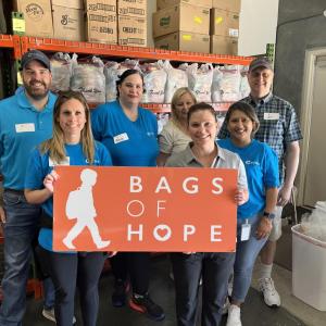 People standing together, holding a "Bags of Hope" sign