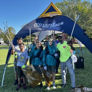 A group of people holding little pickers and bags 