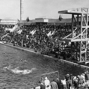 A large swimming pool with swimmers and spectators