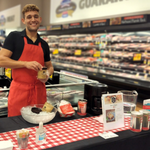 A person standing behind a table with food items