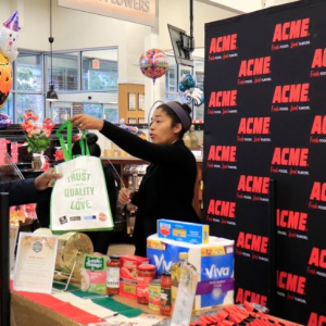 Someone at a booth handing a bag to a customer
