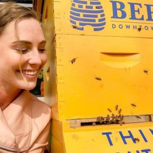 person next to a beehive