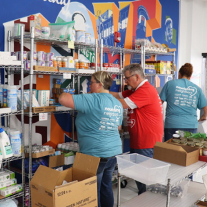 People stocking shelves in food pantry