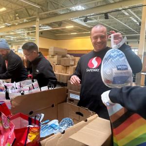 Person putting a turkey in a Thanksgiving meal bag