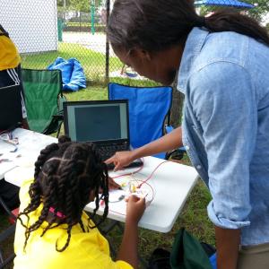 Adult showing laptop to child