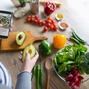 Preparing a meal while looking on a smartphone