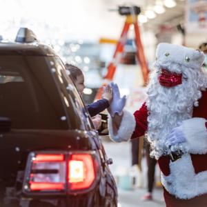 Santa high-fiving child in car