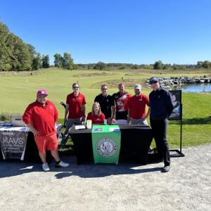 Group of people standing around a table