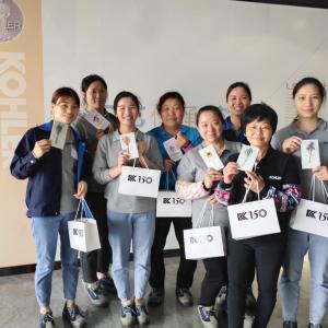 Group of women holding Kohler bags