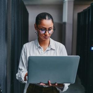 Person standing with open laptop