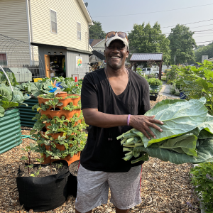 A person in a garden holding greens