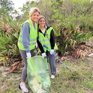 Two friends smile as they volunteer to their time to clean up the Fort Morgan area.