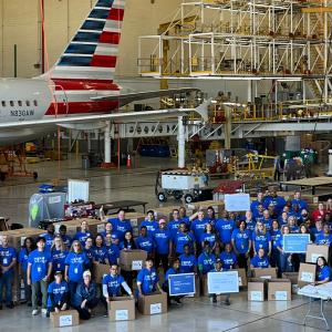 Volunteers stood besides boxes in front of an American Airlines plane