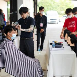 A person sat in a chair getting their hair cut