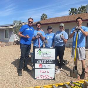 People posing together in front of a house