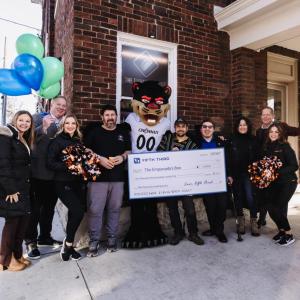 A group of people holding up an oversized check